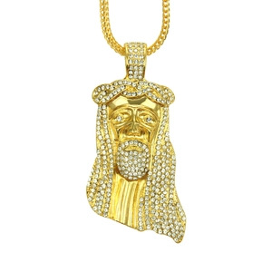 Macro shot of hip hop Jesus pendant with detailed white crystal pavé in gold finish