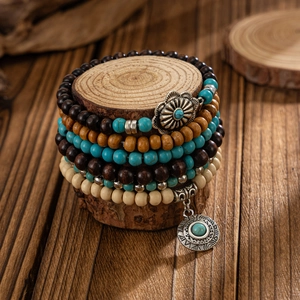 Détail de perles en bois bohème et pierres turquoise sur un bracelet multicouche