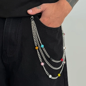 Gros plan sur une chaîne de pantalon argentée triple couche avec billes de strass colorées