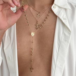 Ensemble de trois colliers dorés avec pendentifs croix minimalistes et chaîne chapelet