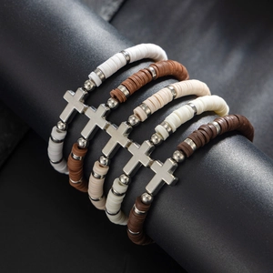 Macro shot of 5-piece bohemian polymer clay Heishi bead bracelets with silver cross charms