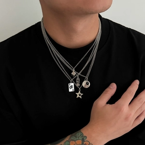 Collana da uomo a strati argento con ciondoli a stella, carta da poker e dadi su t-shirt nera