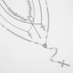 Détail de colliers multicouches argentés avec croix en cristal et pendentif de Jésus