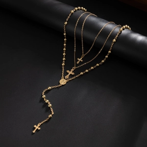 Détail d'un collier chapelet à trois couches plaqué or avec pendentifs croix et médaille