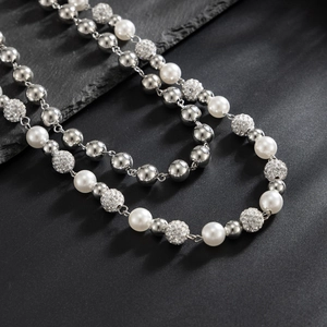 Detail of layered trouser chain with white pearls, silver beads, and rhinestone spheres