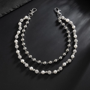 Detail view of double-layer trousers chain with pearls and sparkling rhinestone beads