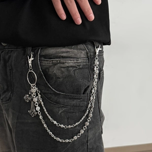 Detail of layered silver pants chain with gothic floral beads and cross pendant