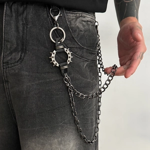 Détail de la chaîne de pantalon punk avec pointes en métal et anneau en cuir sur un jean