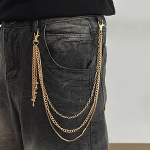 Chaîne de pantalon punk dorée à trois couches avec croix et fermoirs sur un jean