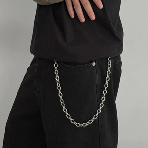 Detail of vintage silver heavy curb trouser chain hanging on black denim jeans
