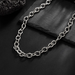 Macro detail of silver O-chain trouser link with textured industrial metal rings