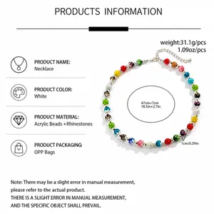 Détails de perles en acrylique colorées et breloques en strass sur un collier tendance