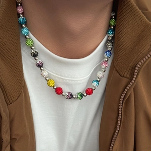 Gros plan d'un collier de perles disco colorées à strass avec séparateurs argentés sur homme