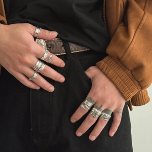 Macro detail of retro silver feather and cross rings with intricate vintage carvings