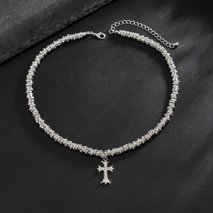 Dettaglio della collana a croce gotica in argento con strass pavé su sfondo nero