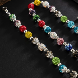 Détail de perles de strass colorées et chaîne en métal argenté avec fermoir mousqueton