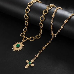 Vintage gold layered necklace with sunburst pendant and emerald green gemstone