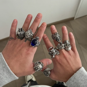 Macro detail of gothic lion and skull rings featuring a dark vintage silver finish