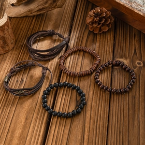 Detail of five men's vintage bracelets with leather cord and wooden beads on wood background