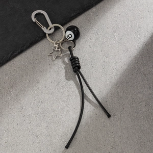 Détail de la chaîne de pantalon avec boule de billard numéro 8 noire et pentagramme
