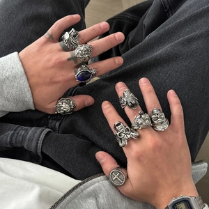 Detail of men's gothic ring set featuring lion, wolf, and eagle heads with a blue gemstone