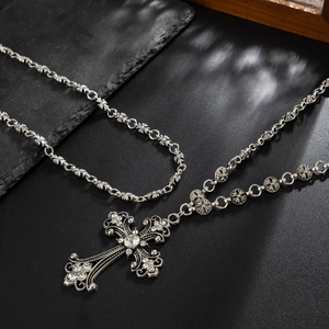 Macro detail of gothic cross necklace with white rhinestones on dark stone background