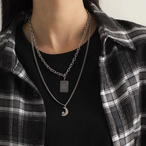 Detail view of double-layer silver stainless steel necklace with star and moon charms