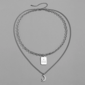 Macro detail of silver double-layer star and moon necklace with engraved Grace pendant