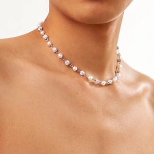 Elegant pearl necklace with crystal paved beads shown on a model neck
