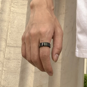 Gros plan d'une bague minimaliste en acier titane noir avec une finition miroir polie