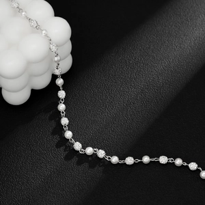 Macro detail of men's pearl necklace with sparkling crystal beads and silver chain