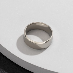 Macro d'une large bague en acier titane poli sur une plateforme en pierre texturée