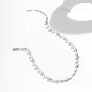 Detail view of pearl and diamond-paved bead necklace with lobster clasp and chain