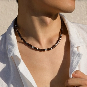 Collier pour hommes en perles de bois avec accents argentés porté par un mannequin