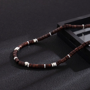 Détails d'un collier en bois bohème avec spirales argentées et perles intercalaires blanches