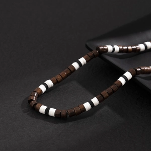 Collier bohème pour hommes avec perles en bois mixtes exposé sur un plateau noir mat