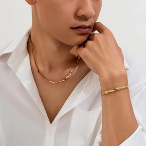 Male model wearing gold twisted snake chain necklace and bracelet set with white shirt