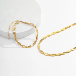 Detailed macro view of a gold-plated twisted snake chain necklace and bracelet set