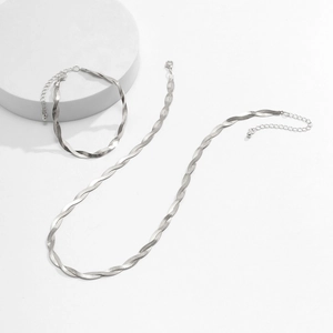 Detailed view of silver herringbone necklace and bracelet set with lobster clasp and chain