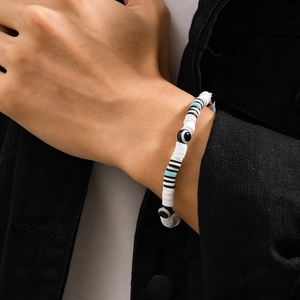 Close-up of evil eye beaded bracelet with black and white heishi clay discs on wrist