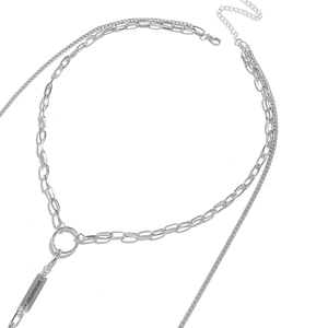 Detailed macro of layered stainless steel chains with Enchanted engraved metal tag