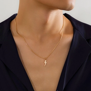 Detailed close-up of a men's gold lightning bolt pendant on a thin box chain necklace