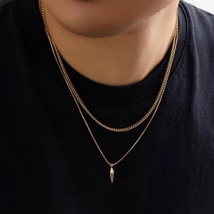 Close-up of men's layered gold cuban and snake chains with a cone pendant on a black shirt