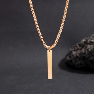 Close-up of minimalist gold box chain necklace with polished vertical bar pendant
