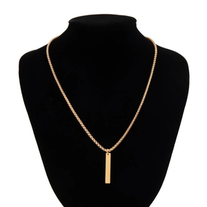 Close-up of polished gold rectangular bar pendant on a box chain over a black neck bust
