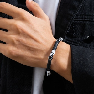 Detailed view of men's black and white polymer clay bead bracelet on wrist
