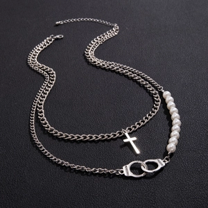 Detail of silver double-layer necklace with pearls, cross pendant and freedom handcuff