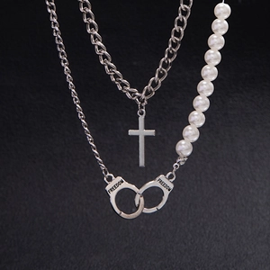 Detailed view of silver handcuff pendant with FREEDOM engraving and pearl layering