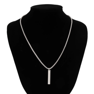 Detail of silver box chain necklace with a minimalist rectangular bar pendant on display