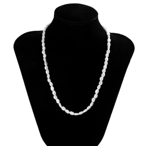 Detailed view of white baroque pearl necklace for men on a black velvet mannequin bust